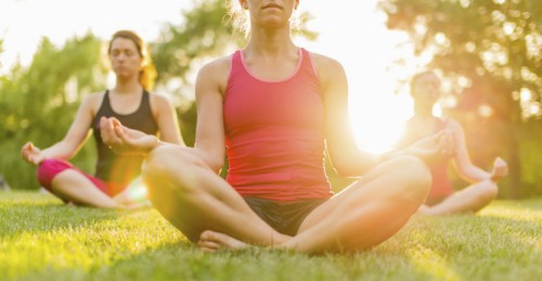 group of 3 women doing yoga in nature